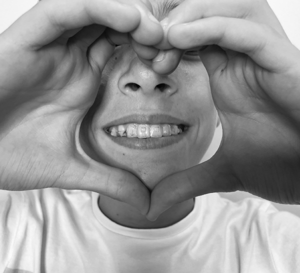Imagen de chico con ortodoncia haciendo un corazón usada para página de tratamientos dentales