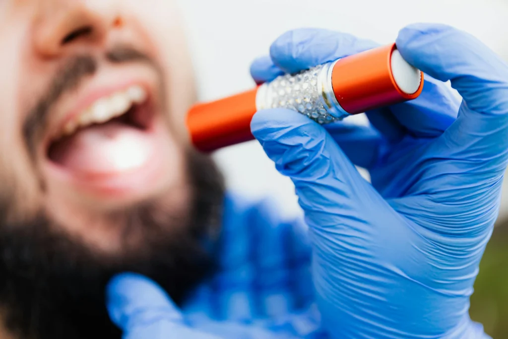 Imagen de chico mientras le revisan la boca con una linterna usada para página de urgencias dentales Mydentiss