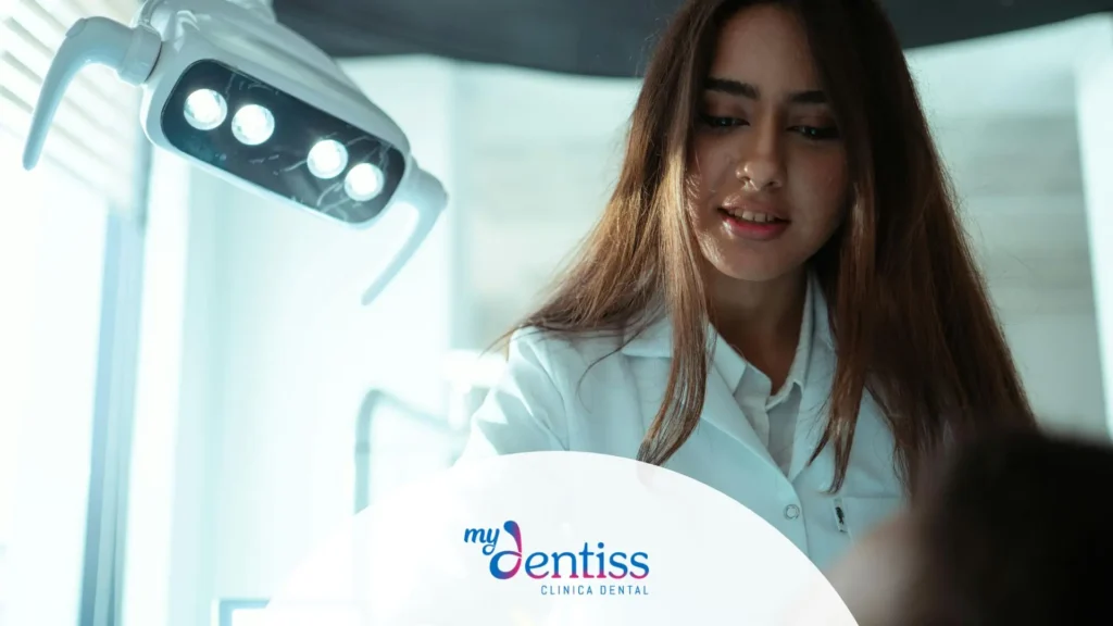 Higienista dental realizando limpieza Airflow sin dolor a paciente en sillón dental