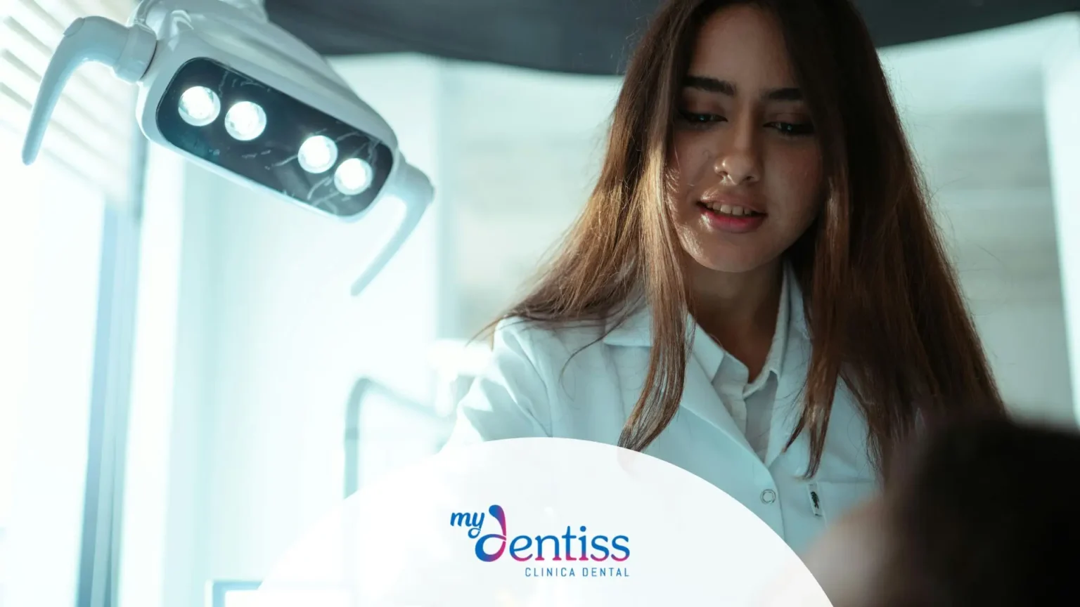 Higienista dental realizando limpieza Airflow sin dolor a paciente en sillón dental