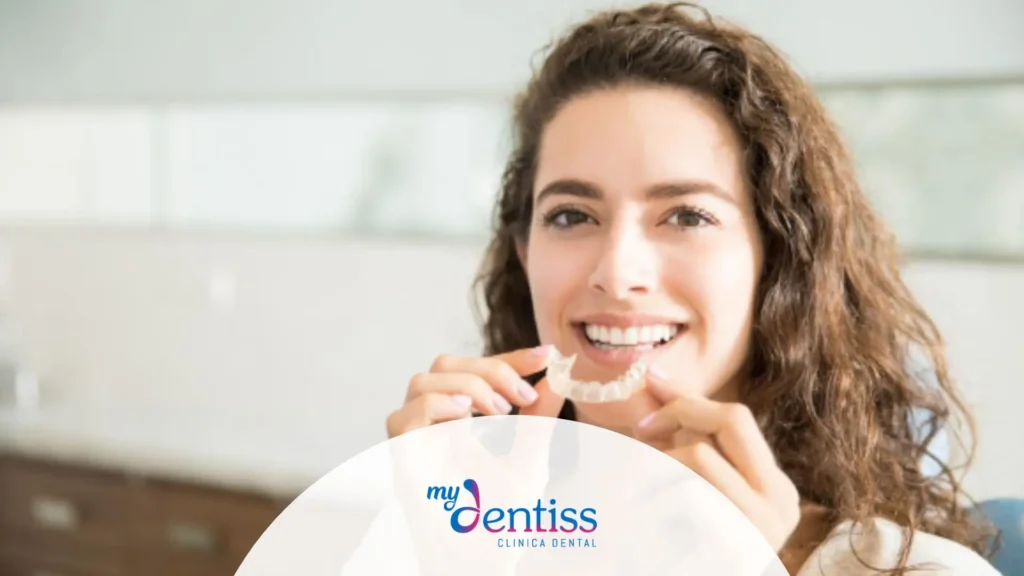 Paciente adulto mostrando sus alineadores de ortodoncia invisible durante revisión dental